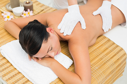 Peaceful brunette enjoying an exfoliating back massage