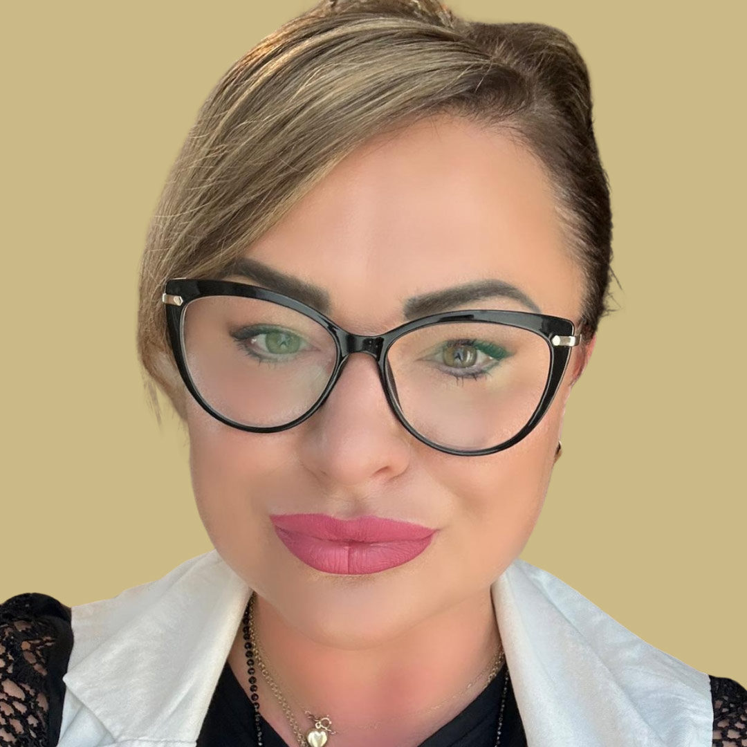 Frau mit Brille, lächelnd, hellbraunes Haar, rosa Lippen, schwarze Spitze, beiger Hintergrund.